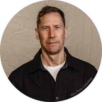 jesper-350x350 Porträttbild på Evelina Kroon i rutig tröja samt kavaj.